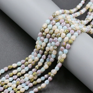 Macro shot of 4mm faceted teardrop crystal glass beads in mixed gradient pastel colors