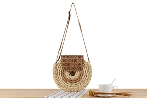 Close-up of woven circular paper rope crossbody bag with retro geometric pattern lid