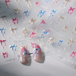 3D bow nail art stickers in pastel blue and pink with iridescent laser finish effect