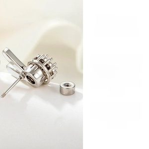 Macro shot of silver titanium steel rotating rabbit ear stud with mechanical gear details