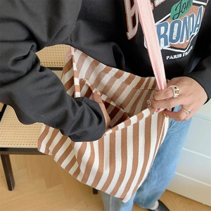 Detail of striped canvas tote with pink strap showing side view and interior opening