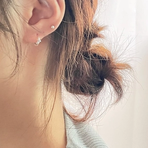 Close-up of minimalist S925 sterling silver knotted hoop and bead earrings on ear