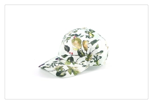 Dettaglio del cappellino bianco con motivo a frutta e visiera ricurva