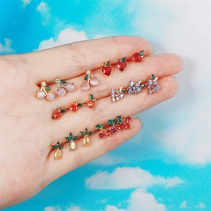 Detailed close-up of colorful fruit-shaped stud earrings with sparkling cubic zirconia