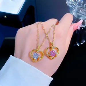 Close-up of heart pendants in gold with micro-inlaid zircon and large center stones