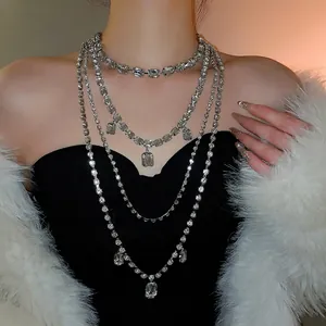 Luxurious layered silver tassel necklace with square crystals on a fashion model