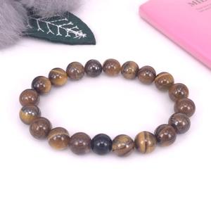 Detalle de una pulsera de cuentas de ojo de tigre natural con una cuenta de obsidiana negra