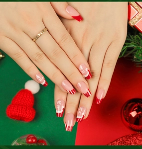 Detailed view of long ballerina Christmas press-on nails with red French tips and Santa hat design