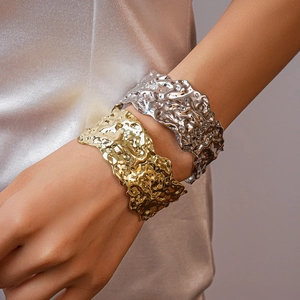 Close-up of gold and silver chunky bangles with irregular molten lava metal texture