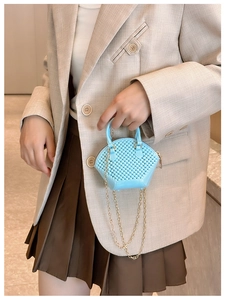 Detailed shot of a mini light blue shell bag with diamond quilt texture and gold chain