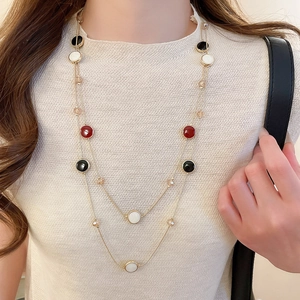 Collier double rang doré avec perles en résine colorées et cristaux porté par un mannequin