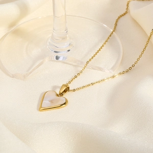 Detail of 18K gold-plated heart pendant with mother of pearl inlay on white silk