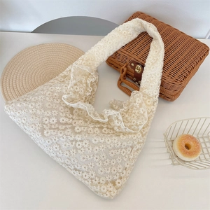 Close-up of white lace daisy embroidery and ruffle edge detail on summer tote bag