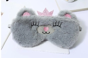 Detailed view of gray plush rabbit sleep mask with pink sequin crown and soft texture