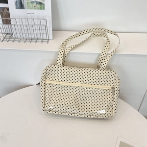 Detail of canvas tote bag with black polka dots and a clear front PVC zipper pocket