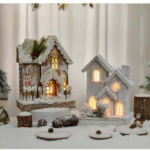 Macro detail of lighted wooden Christmas house with snow effect and warm LED window glow
