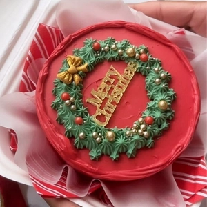 Merry Christmas acrylic cake topper in gold on red and green festive holiday wreath cake
