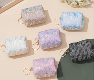 Vista plana de mini monederos de lentejuelas de colores con llaveros dorados