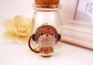 Close-up of cute monkey keychain featuring brown and gold sparkling rhinestones and metal