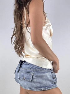 Y2K style light gold satin camisole with blue denim mini skirt on professional model