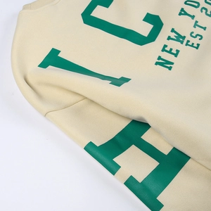 Gros plan d'un sweat-shirt crème avec imprimé New York City en lettres vertes