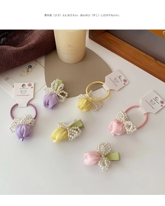 Close-up of silk tulip hair accessories with white pearl beads and elegant textures