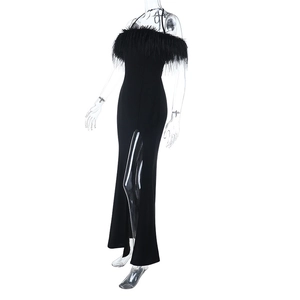 Détail d'une élégante robe de soirée noire avec plumes au décolleté et fente haute