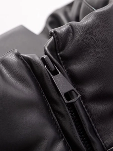 Gros plan sur la texture du cuir noir et la fermeture éclair métallique mate de la veste