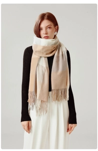 Detail of plaid scarf featuring beige and brown soft cashmere texture with tassels