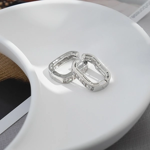 Luxury silver brass geometric earrings set with clear zircon stones on a white stand
