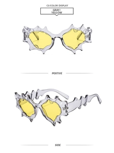 Detail view of avant-garde flame-shaped sunglasses in gray transparent frames with yellow lenses