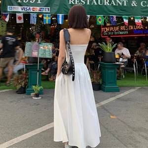 Elegantes weißes trägerloses Maxikleid mit rückenfreiem Design in einer Straßenszene im Freien