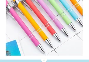 Macro shot of colorful matte retractable ballpoint pens with metallic accents on desk