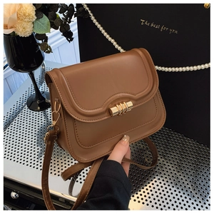 Detail of premium brown PU leather bag with gold metal twist lock and vintage flap closure