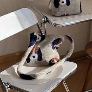 Sac bandoulière en peluche beige avec motif chien de dessin animé sur une chaise blanche