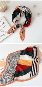 Detail of pleated silk scarf featuring vibrant orange, green, and geometric color blocks