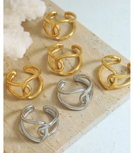 Intertwined gold and silver titanium steel rings displayed on a textured stone surface