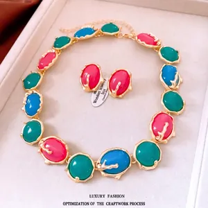 Vintage resin jewelry set with wavy gold frames and colorful oval stones in a box