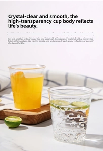 Close-up of clear disposable airline cups with juice and lime slices on marble table