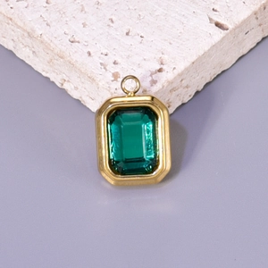 Titanium steel gold square pendant with emerald-cut green crystal on a stone block