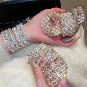 Detail of multi-layer pearl bracelet with sparkling rhinestones on model's wrist