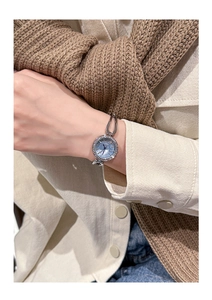 Macro shot of a GEDI women watch with blue dial and diamond bezel on a silver chain strap