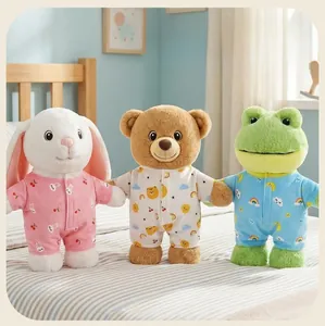 Detailed view of plush rabbit, bear, and frog toys in patterned pajamas on a soft bed