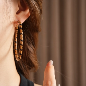 Gros plan de boucles d'oreilles créoles en cuir imprimé léopard au design vintage chic