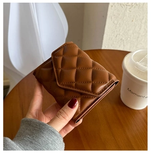 Close-up of brown quilted leather trifold wallet with classic diamond stitch pattern