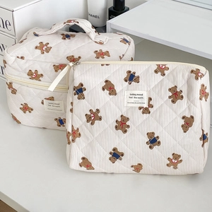 Detailed view of quilted cotton travel bags featuring striped patterns and bear prints