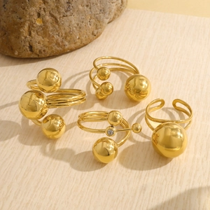 Close-up of adjustable gold spherical rings set with mirror finish and zircon detail