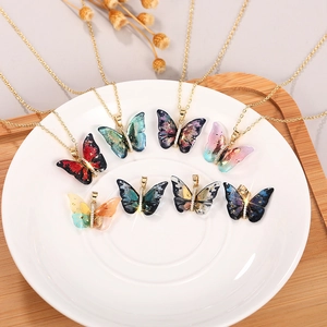 Detailed view of colorful acrylic butterfly pendants with sparkling crystal inlay