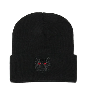 Close-up of tiger head embroidery with red eyes on black ribbed knit beanie cap
