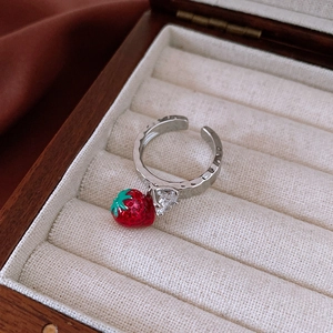 Detailed macro shot of strawberry pendant ring with heart zircon in a wooden box